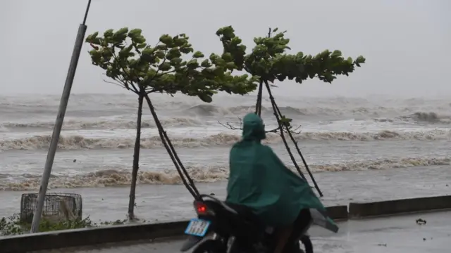 Một người dân đi xe máy trên bờ biển huyện Diễn Châu, tỉnh Hà Tĩnh trước khi bão Doksuri đổ bộ. Bão Doksuri được cho là cơn bão mạnh nhất vào Việt Nam trong một thập kỷ qua.