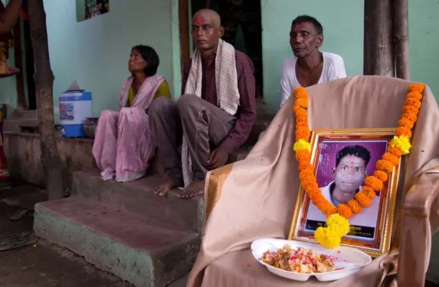 ప్రవీణ్ సోయమ్ ఫొటో పక్కన అతడి కుటుంబ సభ్యులు