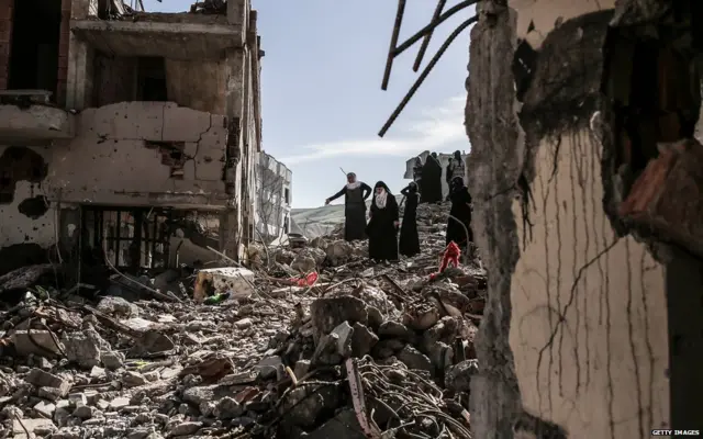 Люди у обломков своих домой на юго-востоке Турции