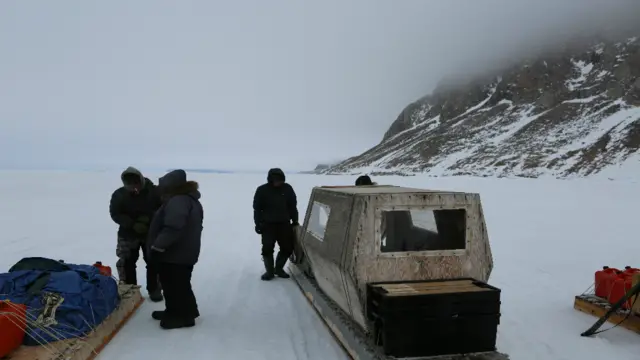 Residentes del pueblo preparan un trineo para viajar.