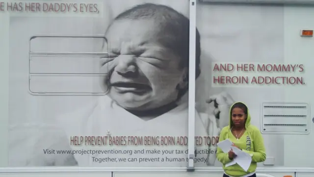 Mujer de pie al lado de un camión.