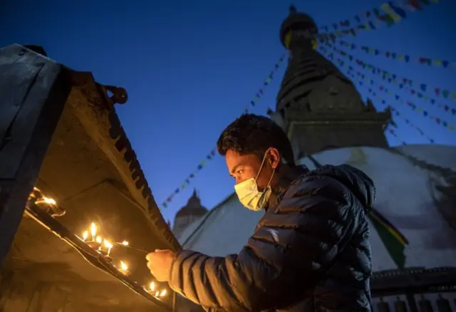 मास्क लगाएर बत्ती बाल्दै