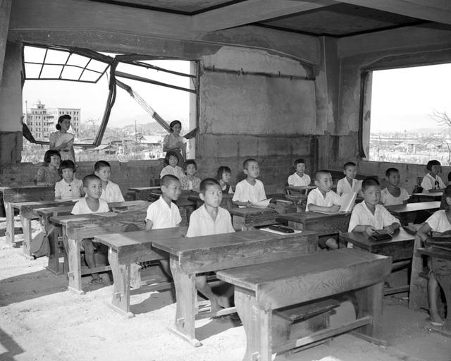 1946年，学生在被毁坏的教室里继续上课，废墟下仍然有数以千计的死难者。