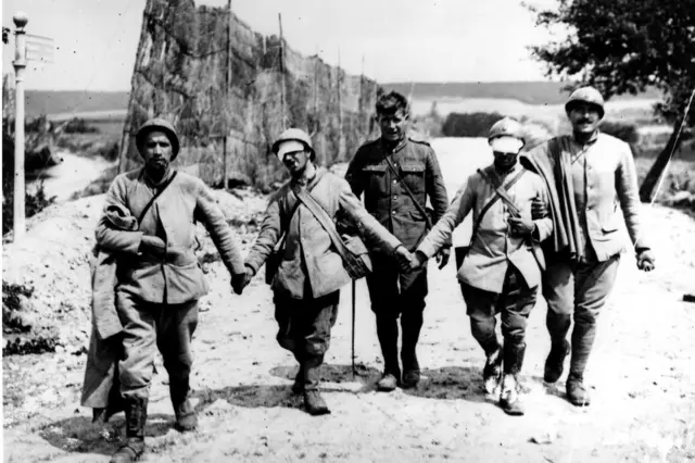 1918 में मार्न की दूसरी लड़ाई में जर्मन सेनाओं के गैस अटैक में ज़ख़्मी फ्रेंच सैनिकों को निकालते ब्रितानी सैनिक