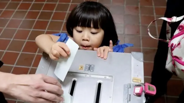 Niña metiendo una papeleta