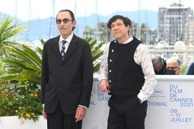 Участники рок-группы Sparks - братья Рон и Рассел Мэйл, авторы сценария и музыки к фильму открытия "Аннет" - позируют перед фотографами в день открытия фестиваля