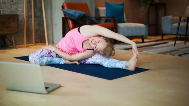 Mulher fazendo yogacassinos que dão dinheiro gratisfrente a notebook