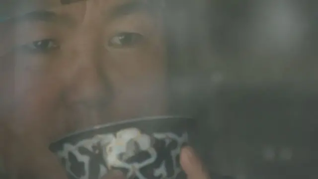 เงาสะท้อนของ กูลซีรา กำลังยกถ้วยขึ้นดื่ม