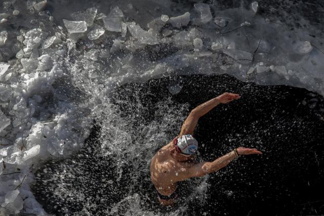 严寒并没能令北京的冬泳爱好者却步，依然有人在已部分结冰的河里畅游。