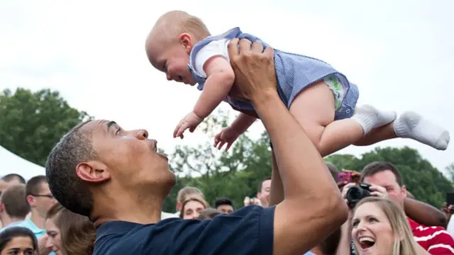 Barack Obama alza a un bebé durante la celebración del Día de la Independencia en la Casa Blanca, el 4 de julio de 2012.