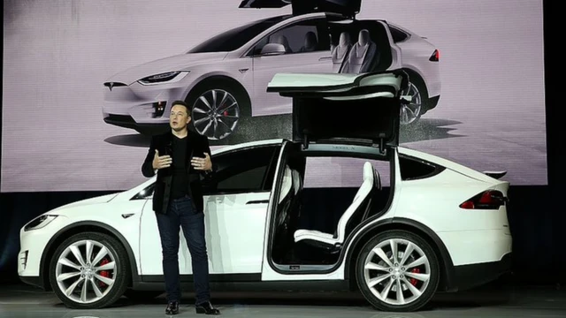 Elon Musk próximo a um carro elétrico da Tesla