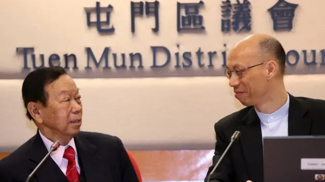 區議會是地區諮詢組織，香港政府官員有些時候會出席部份會議講解政府的政策。上圖是環境局局長黃錦星（圖右）2014年出席一次屯門區議會會議，講述政府計劃擴建當區一個垃圾堆填區的計劃。