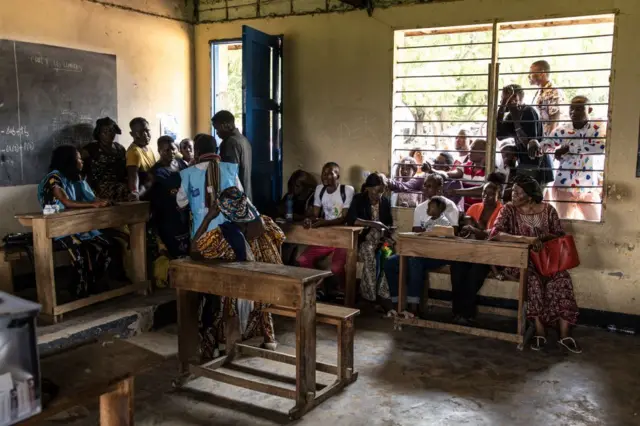Des électeurs attendent de voter à l'extérieur d'un bureau de vote à Kinshasa, en République démocratique du Congo.