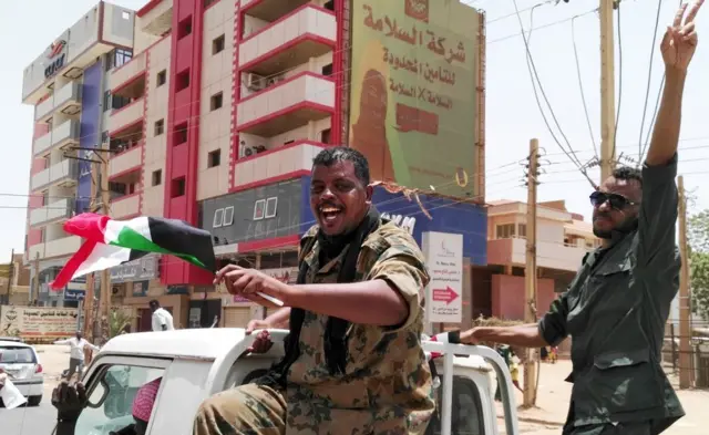 A nan kuma wani soja ne tare da wani farar hula suna nuna murnarsu da labarin hambare Shugaba al-Bashir daga mulki a Sudan.