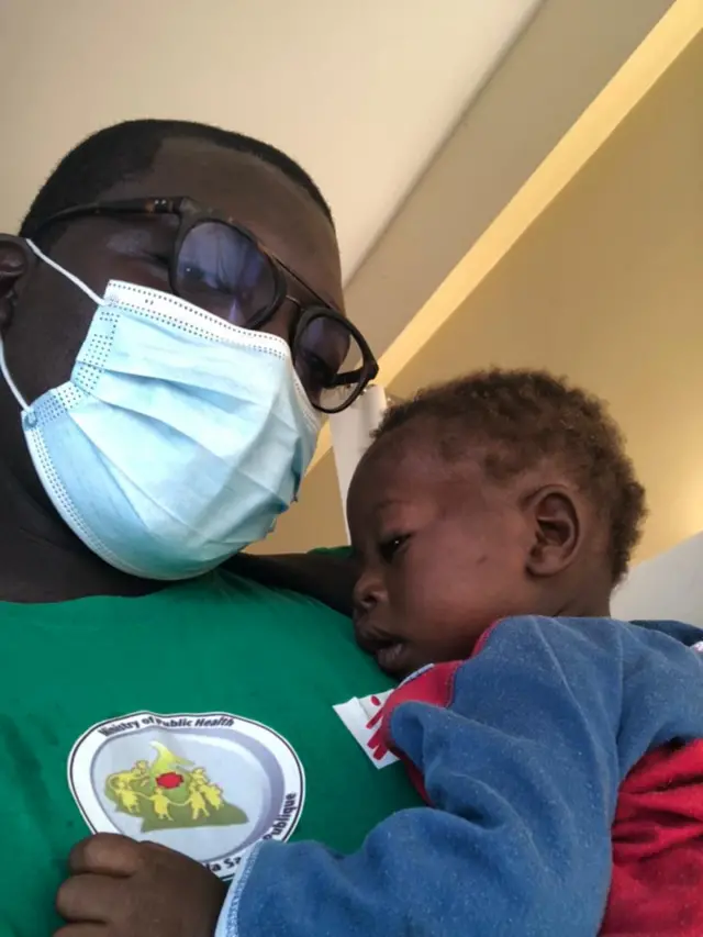 Le bébé avec le Dr Yonta qui la porte sur sa poitrine