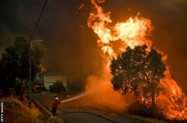 A firefighter tackles a wildfire close to the village of Pucarica in Abrantes on August 10, 2017