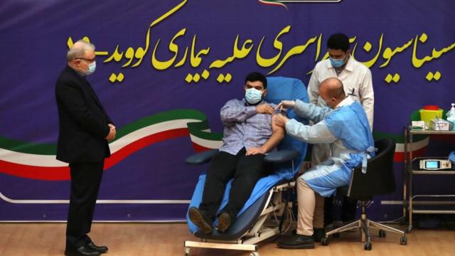 伊朗衛生部長薩伊德·納瑪琪（Saeed Namaki 左）陪兒子帕爾薩（Parsa）接種第一劑衛星五號疫苗。