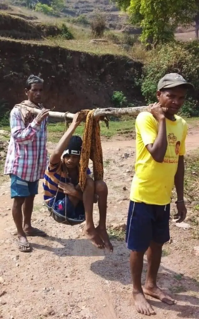 నడవలేని యువకుడిని డోలీలో మోసుకెళ్తున్న గిరిజనులు