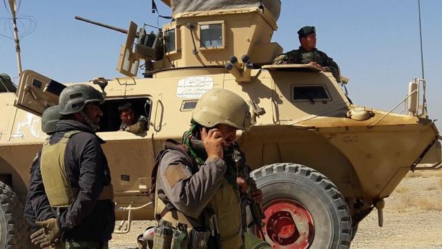 Afghan security forces stand near an armoured vehicle during ongoing fighting between Afghan security forces and Taliban fighters in the Busharan area on the outskirts of Lashkar Gah, the capital city of Helmand province May 5, 2021.