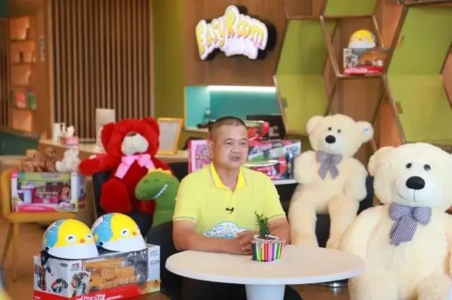 พล.อ. ณรงค์พันธ์ จิตต์แก้วแท้ ปรากฏตัวในชุดเสื้อสีเหลืองของจิตอาสาพระราชทาน โดยมีตุ๊กตาหมีหลายตัวเป็นฉากหลัง