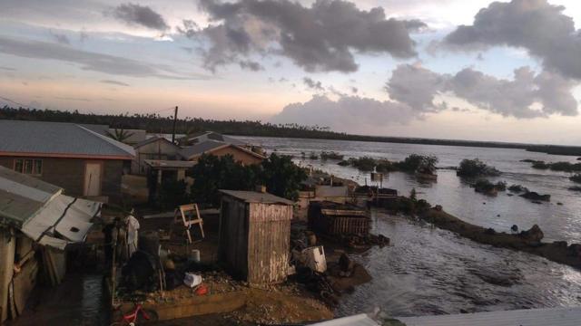 쓰나미 파도가 시작되면서 해변가 집들이 물에 잠겨있다