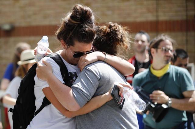 Mujeres se abrazan y lloran en la zona de la Torre Grenfell, edificio calcinado en Londres