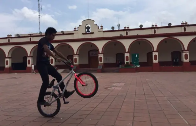 Un joven se divierte en una bicicleta en el centro de Chilapa.