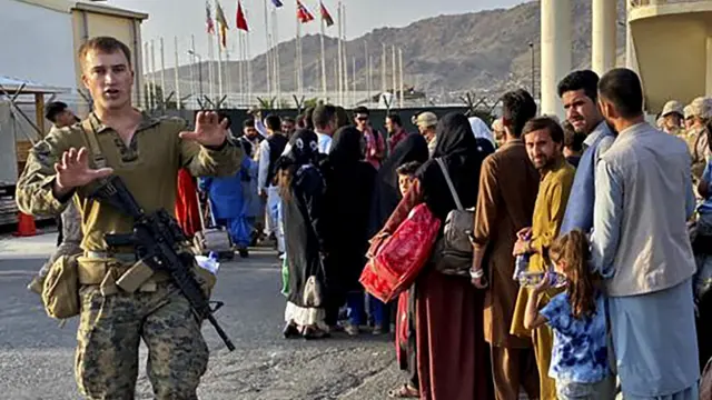 కాబుల్ విమానాశ్రయంలో ప్రయాణికులను అదుపు చేస్తున్న అమెరికా సైనికుడు