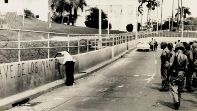 Un hombre hace una pintada de "Ave. de los Mártires" frente a la policía zoneíta.