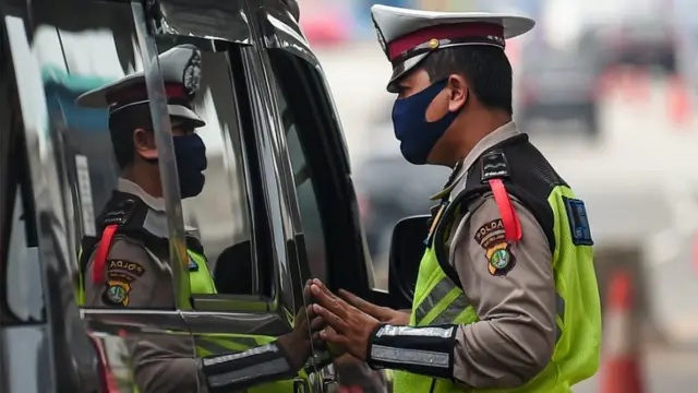 Petugas kepolisian memeriksa sejumlah kendaraan yang melintas di jalan tol Jakarta-Cikampek, Cikarang Barat, Jawa Barat, Selasa (19/5/2020)