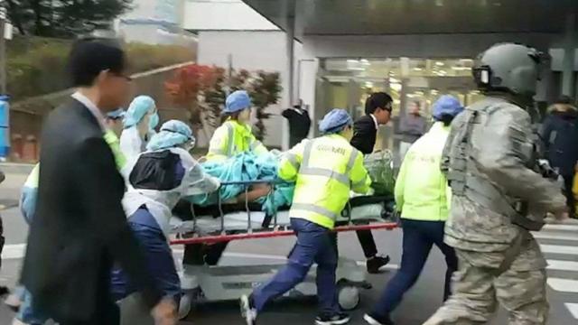 Los médicos trasladan al desertor herido en una camilla dentro de un hospital.