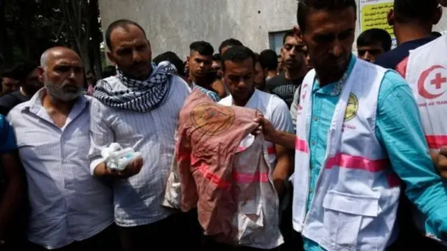 مشيعون حملوا سترة رزان الطبية الملطخة بالدماء أثناء تشييع جثمانها