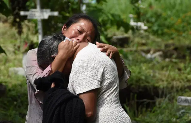 Dos familiares de víctimas del Volcán de Fuego, que hizo erupción el 3 de junio de 2018 en Guatemala, se abrazan.