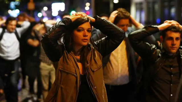 在场民众双手置于头上配合警方疏散。