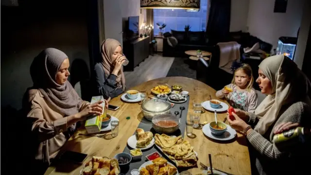 A family sits at the table during the iftar, the meal after sunset during the Islamic fasting month of Ramadan in