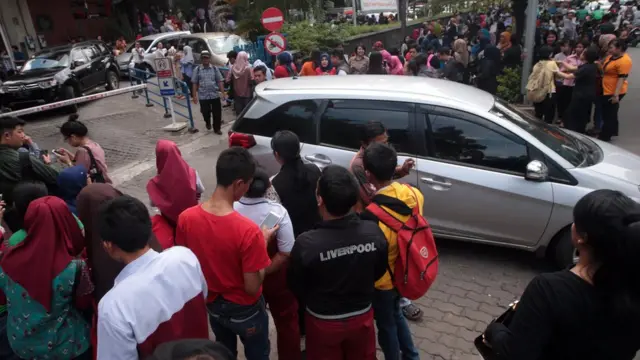 Warga berada di luar gedung setelah gempa pada Selasa (23/01) siang.