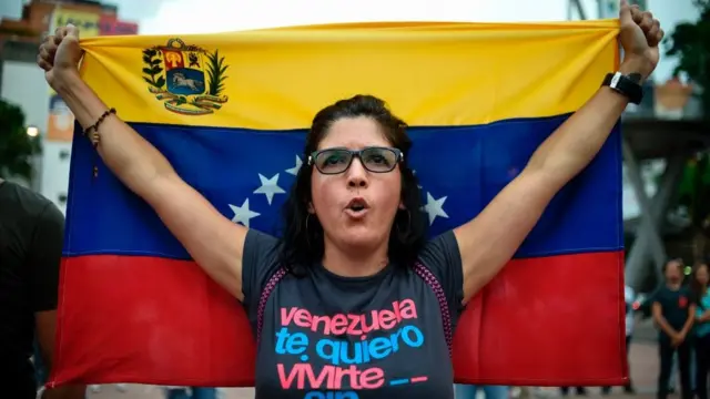 Una mujer con una bandera de Venezuela.