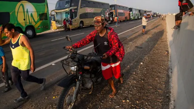 Personas caminando en un tramo bloqueado de la carretera Panamericana.