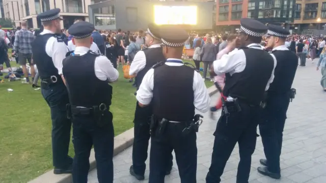 Petugas keamanan yang turut menonton bersama-sama warga London.