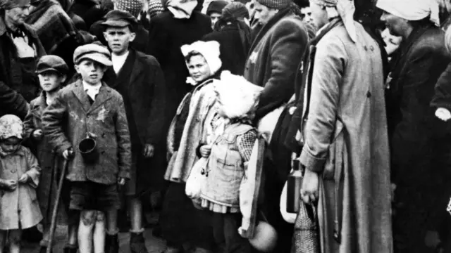 نساء وأطفال يهود ينزلون من الحافلات عند وصولهم إلى معسكر للإبادة في أوشفيتز في يناير 1942