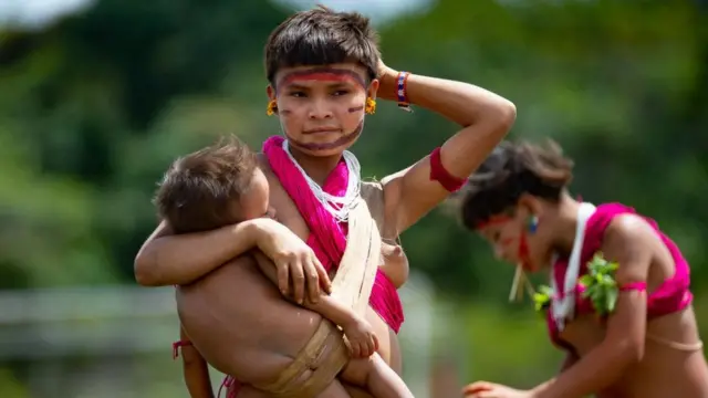 Mulher da etnia indígena Yanomami com uma criança nos braços