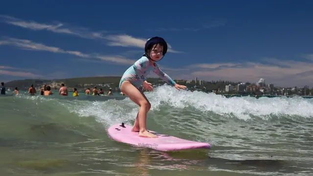 Menina surfando na Freshwater Beachsaque no galera betSydney, na Austrália