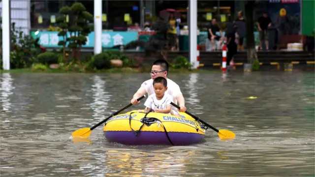 A man and his son rows in an inflatable kayak