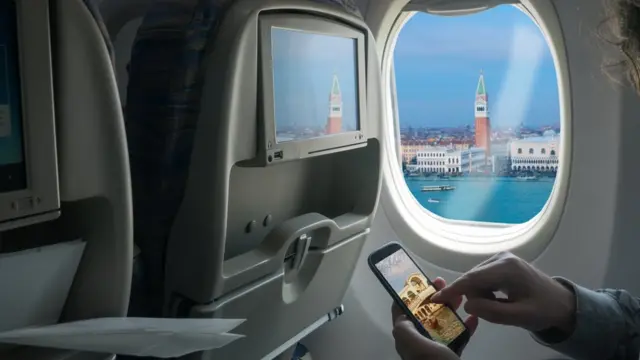 Чоловік користується мобільним в літаку