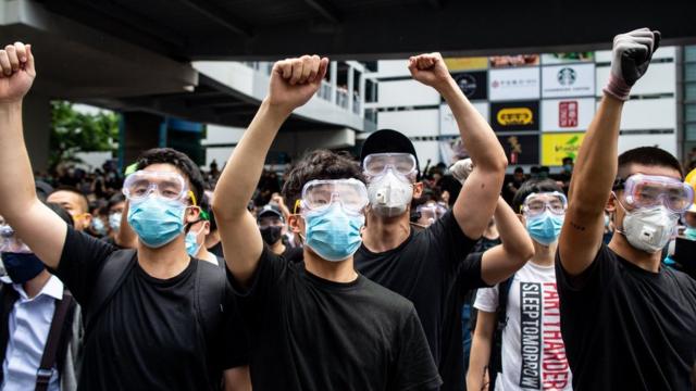 Protesters in masks and goggles chant slogans outside the Legislative Council in Hong Kong on June 12, 2019