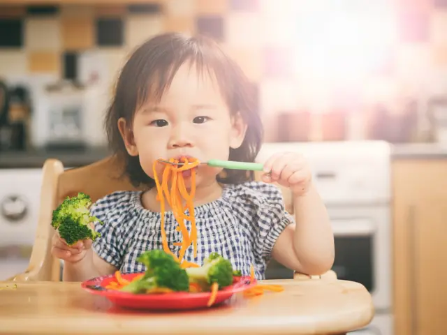 Menina comendo legumes