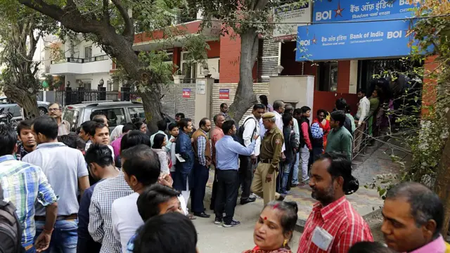 બૅન્કની બહાર લાઇનમાં ઊભેલા લોકો