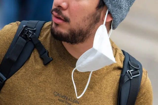 мужчина с маской на ухе