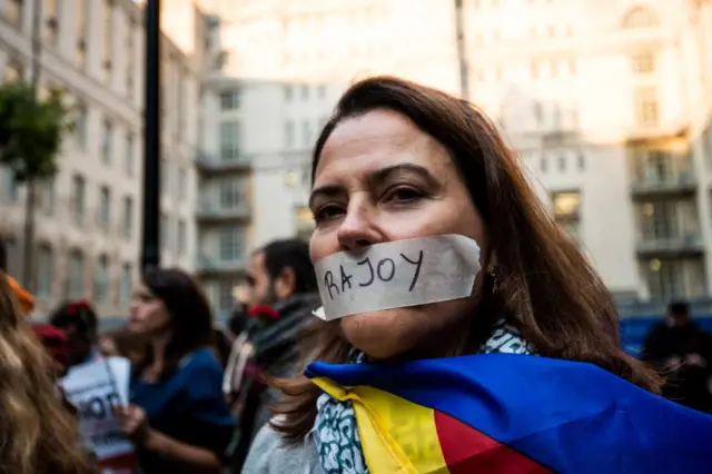 Mujer con la boca tapada con una cinta en la que se lee "Rajoy".