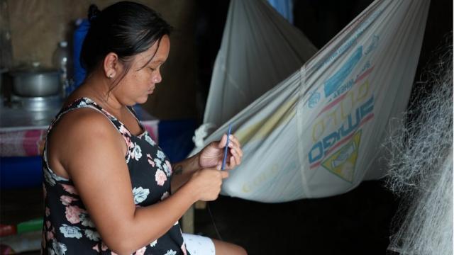 菲律宾巴拉望岛上，一名妇女正在修理渔网